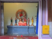 Many small shrines line the walls around the inside of the temple and people leave gifts of food and lotus blossoms in front as they pray.